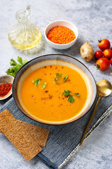 Winter spicy lentil cream soup on light blue background