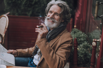 Happy bearded man smoking cigar stock photo