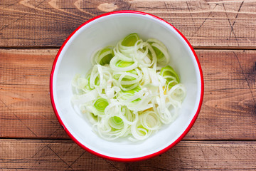 Step-by-step preparation of egg salad with leek and dill, step 1 cutting of leek, selective focus, top view