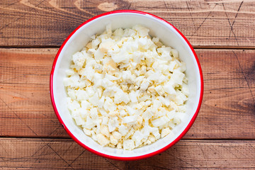 Step by step cooking of egg salad with leek and dill, step 2 adding chopped boiled eggs, selective focus, top view