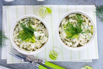 Salad with leek and eggs in portioned white bowls, horizontal, top view