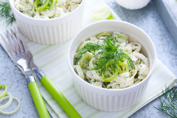 Spring salad with leek and eggs in portioned white bowls, horizontal