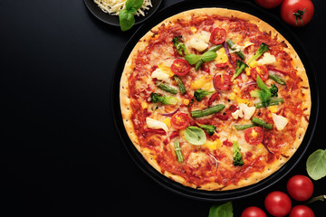 Top view of appetizing vegetarian pizza with cheese, olives, basil and fresh vegetables