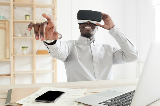 African IT engineer working with virtual reality headset in modern loft office. VR technology