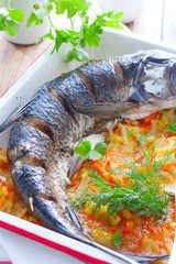 Whole carcass baked white cupid with enameled vegetables, selective focus