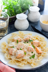 Farfalle with salmon in a creamy sauce, selective focus