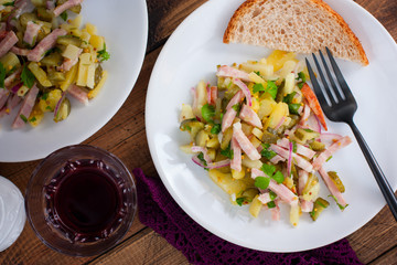 traditional german potato salad with sausage and pickled cucumbers, horizontal, top view