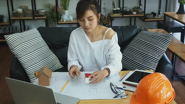 An architect or engineer uses a vernier to measure the size of a house model. Architectural concept.