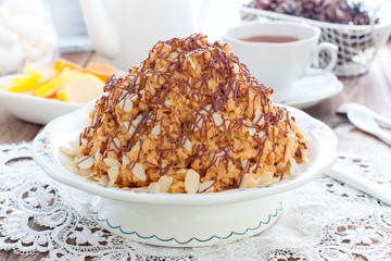 Traditional Russian anthill cake decorated with chocolate and almonds, horizontal