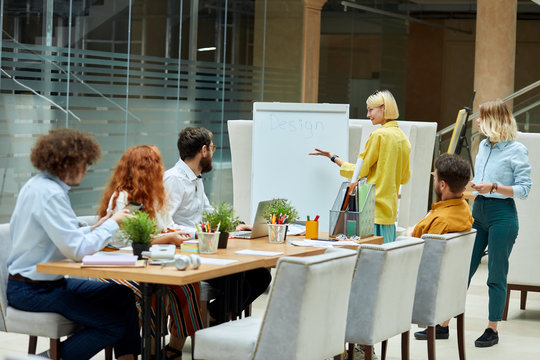 Daily meeting of talented young designers in modern coworking office, working atmosphere, team of young creative graphic designers study new business project