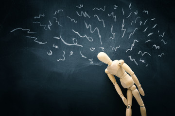 image of wooden dummy over blackboard with worried stressed thoughts. depression, obsessive...