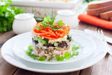 Salad with mushrooms, prunes, Korean carrots on a white plate, selective focus