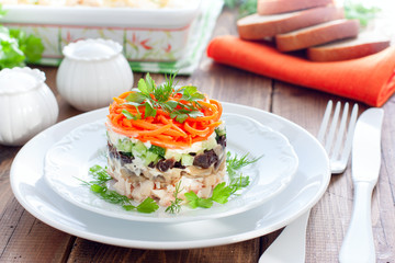 Salad with mushrooms, prunes, Korean carrots on a white plate, selective focus