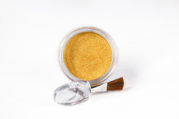 Gold eye shadows and eye brush  isolated on white background. Concept of makeup and beauty.
