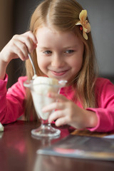 Girl in a cafe eats ice cream. Photographed close-up.