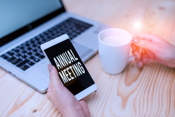 Handwriting text Annual Meeting. Conceptual photo yearly meeting of the general membership of an organization woman laptop computer smartphone mug office supplies technological devices