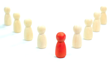 Leadership concept. Red wooden figurine leading the other wooden figurines.
