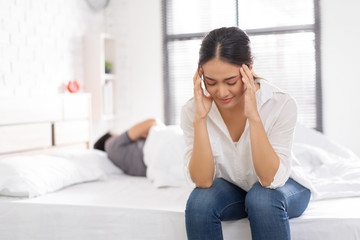 couple,they have problems with quarrel. woman sitting in bed She is having a headache