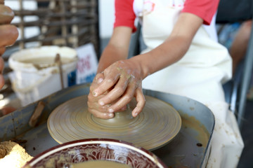 Fototapeta na wymiar Kid works on pottery wheel
