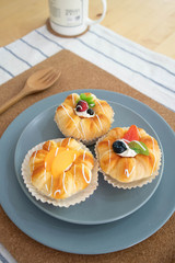 A blue plate of fruit buns on the table -squishy