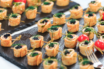 Assortment of various snacks and canapes on a plate during a coffee break at a business seminar
