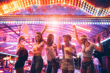 Friends dancing in the amusement park	