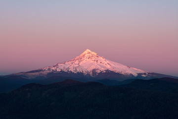 Fototapeta na wymiar Mount Hood Covered in Snow, active stratovolcano and highest mountain in Oregon. Panoramic View from Sherrard Point, Fire Lookout at the top of Larch Mountain. Sunset, Purple Sky, Glowing Summit