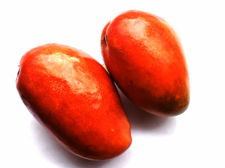 Red-orange mangoes on a white background