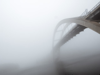 A bridge disappears into thick fog