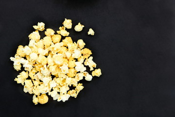 Top view of many salted popcorn mix with cheese popcorn pile on black table background, have copy space for put text