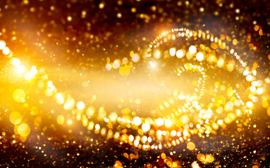 Golden Christmas and New Year glittering stars swirl on black bokeh background, backdrop with...