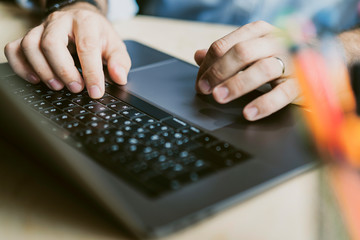 Man sitting at desk,working on laptop.Close-up male hands typing on keyboard. Businessman working on Internet.Online homebased job