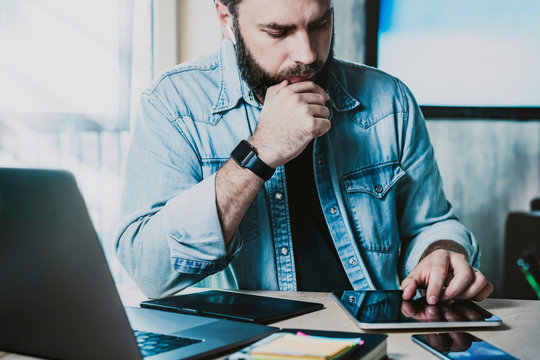 Product manager busy at office workplace learning data, innovative solutions on tablet and laptop.Digital developer testing work