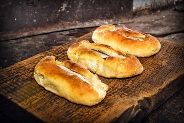 Homemade fish pies on a wooden textured surface against a background of stove brickwork
