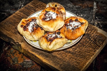 Homemade open pies with berry filling in a plate on a wooden textured surface