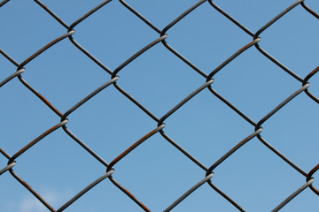 Wire mesh or netting fence against the sky