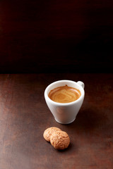 Cup of coffee with amaretti (Italian biscuits) on rustic wooden background. Copy space.