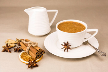 Masala tea is a traditional Indian drink in a Cup with spices on a light background