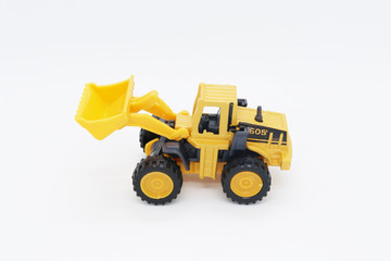 Yellow toy tractor isolated on white background.