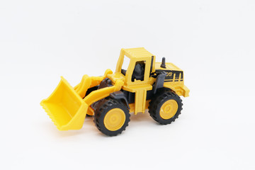 Yellow toy tractor isolated on white background.