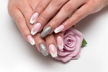 Foto op Plexiglas Manicure Bruiloft scherpe Franse manicure met zilveren pailletten op de ringvingers op een witte achtergrond close-up op lange nagels met een roze roos in de hand