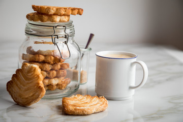 Italienische Blätterteig Fächer Kekse mit Einmachglas und Becher Kaffee auf Marmor Hintergrund