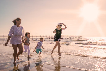 happy family is running on the beach in a sunny day