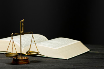 Law concept - Open law book with a wooden judges gavel on table in a courtroom or law enforcement office isolated on white background. Copy space for text.