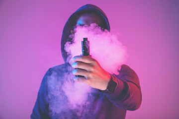 vaping man holding a mod. A cloud of vapor.
