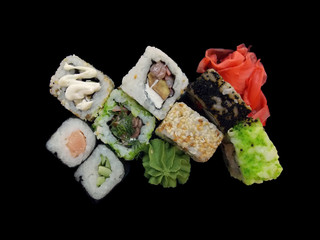 Fish sushi with ginger and wasabi on a black background.