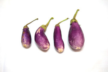 Fresh raw Purple Eggplant in a special wicker basket for Eggplant on white background. Top view, Different sizes