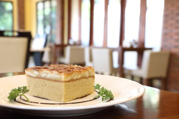 Close up toffee cake in white plate on wooden table in restaurant look delicious, have copy space