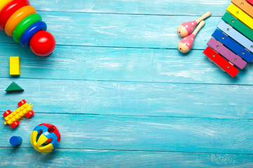 Colorful kids toys frame on wooden background. Top view. Flat lay. Copy space for text.
