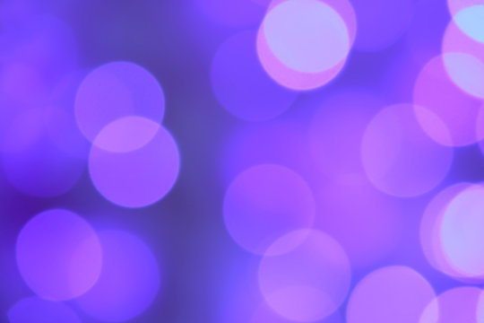 Many soft blue and purple blurry bokeh light on purple tone background in Christmas and New Year festival day, can use for background